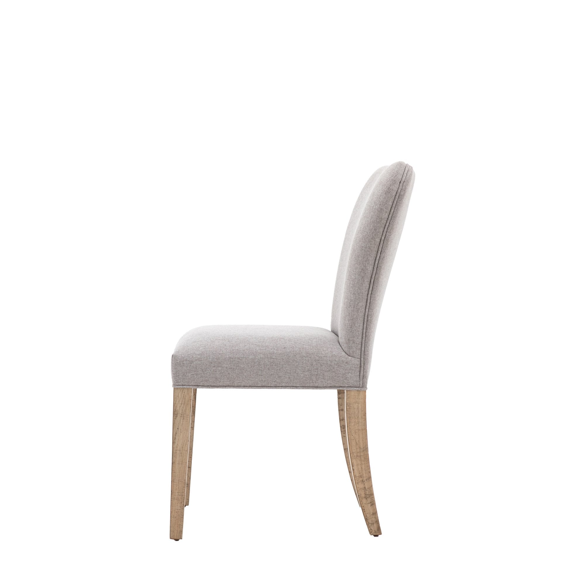 Side view of a single grey fabric upholstered dining chair with light wooden legs.