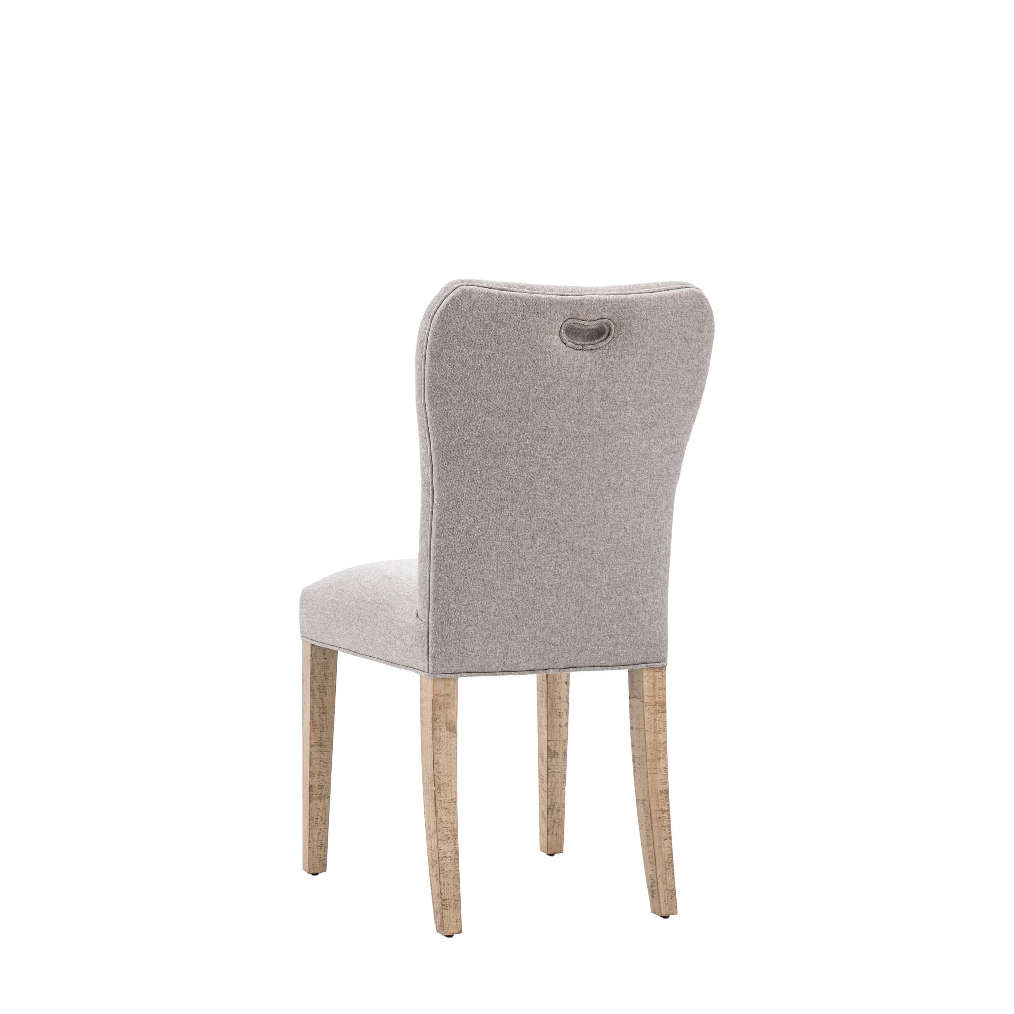 Back view of a single grey fabric upholstered dining chair with a handle cutout and light wooden legs.