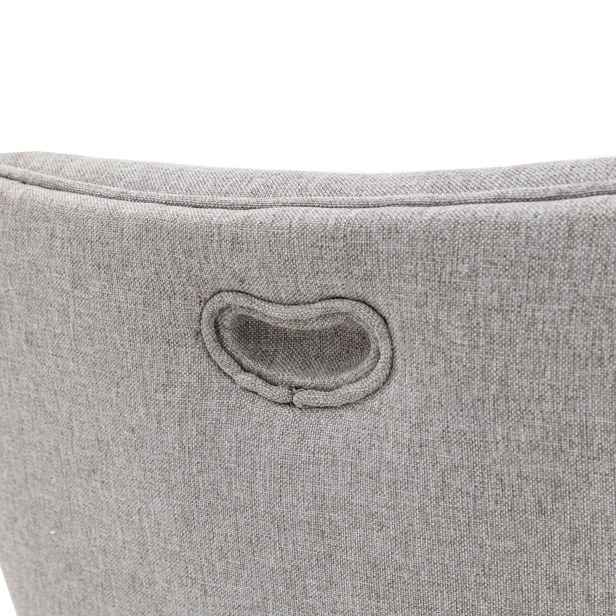 Close-up of the handle cut-out detail on the back of the grey fabric upholstered dining chair.