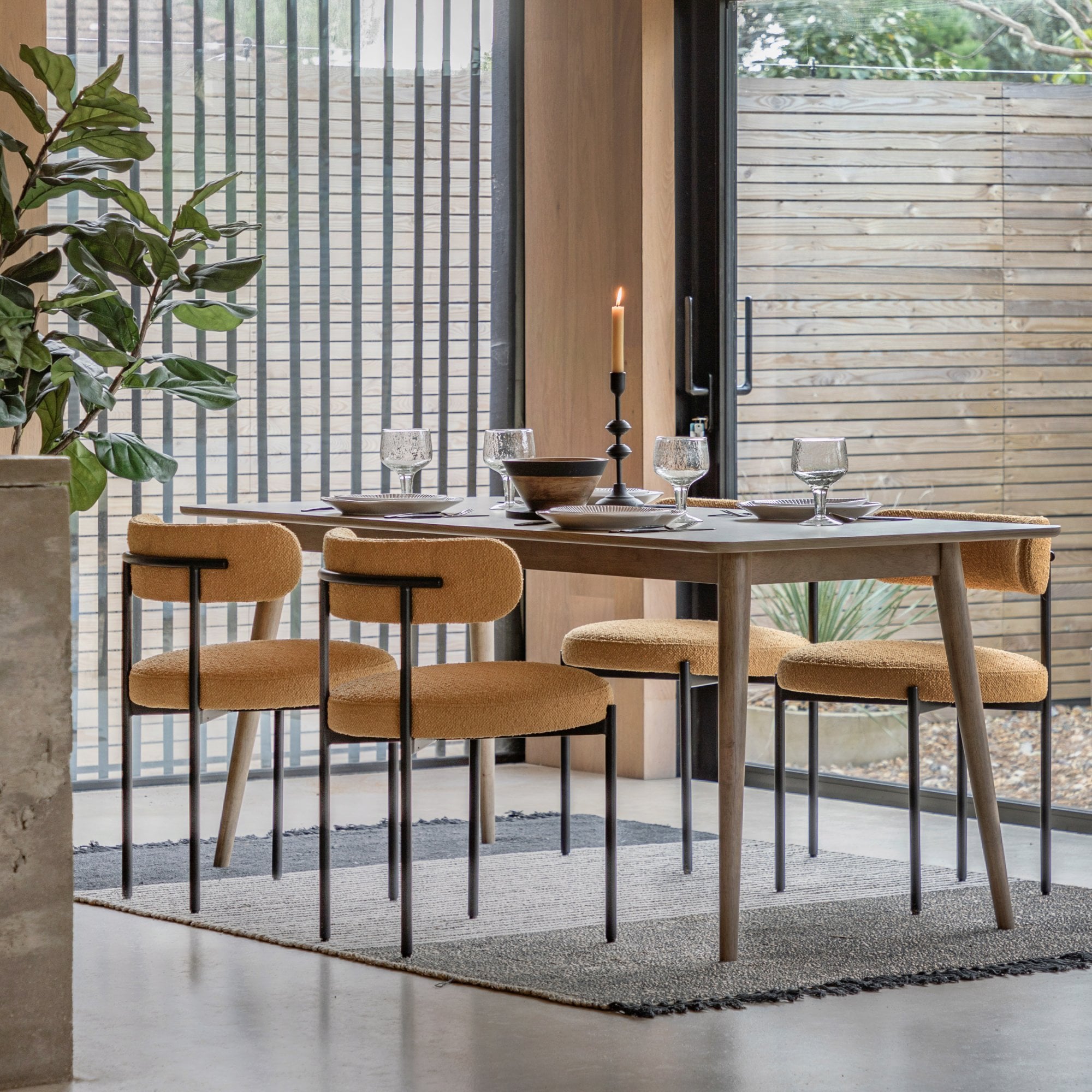 A modern dining room featuring a sleek wooden table with four bright yellow chairs.