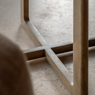 Close-up view of the table's wooden base, featuring a cross-shaped design.