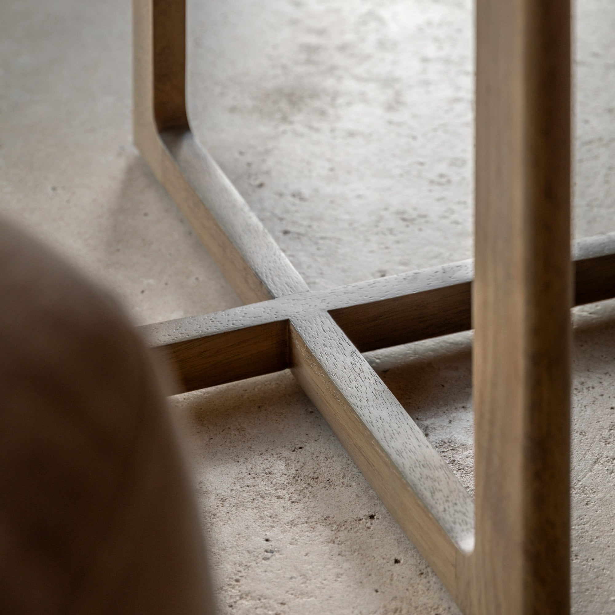 Close-up view of the table's wooden base, featuring a cross-shaped design.