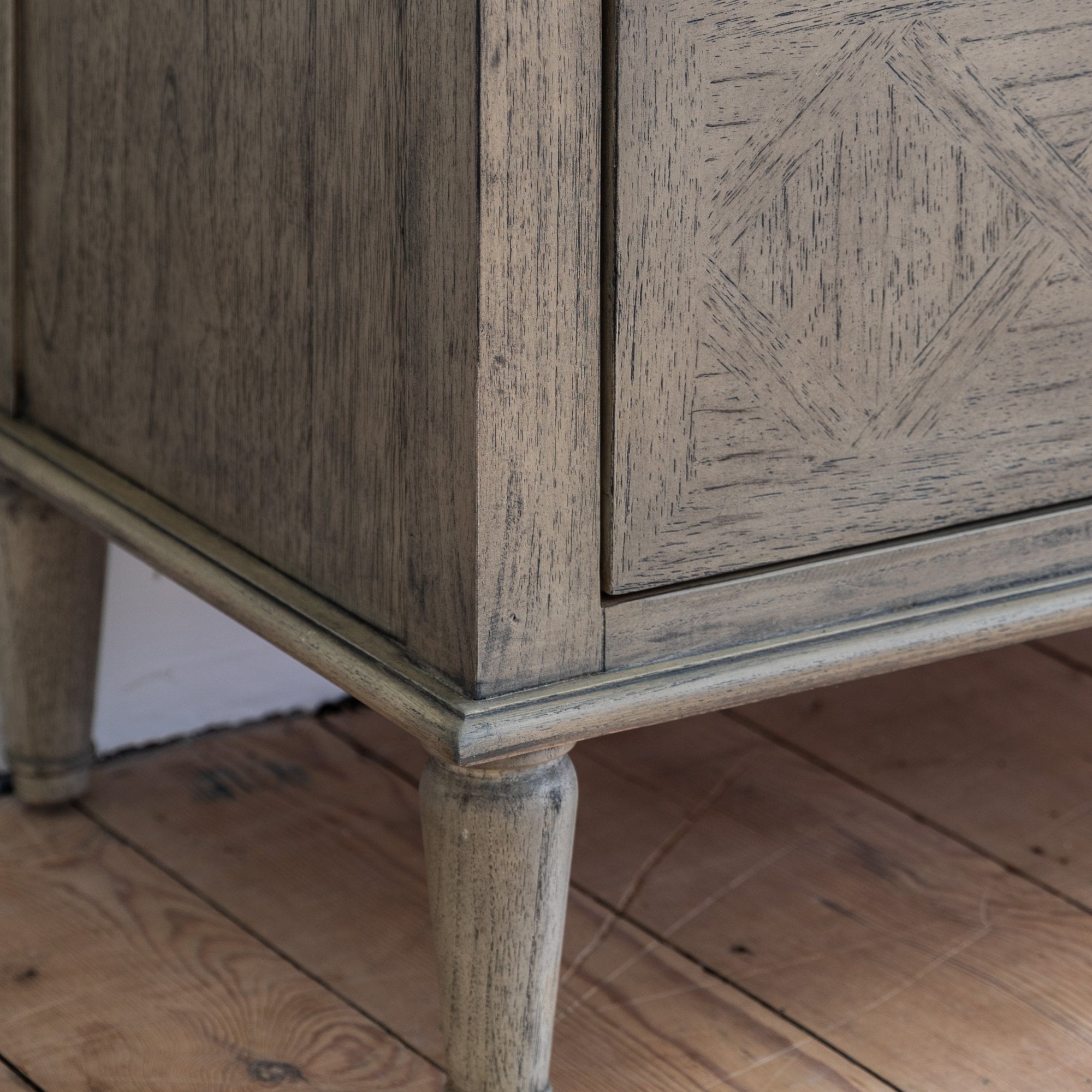 Close-up of the dresser's base and tapered legs.