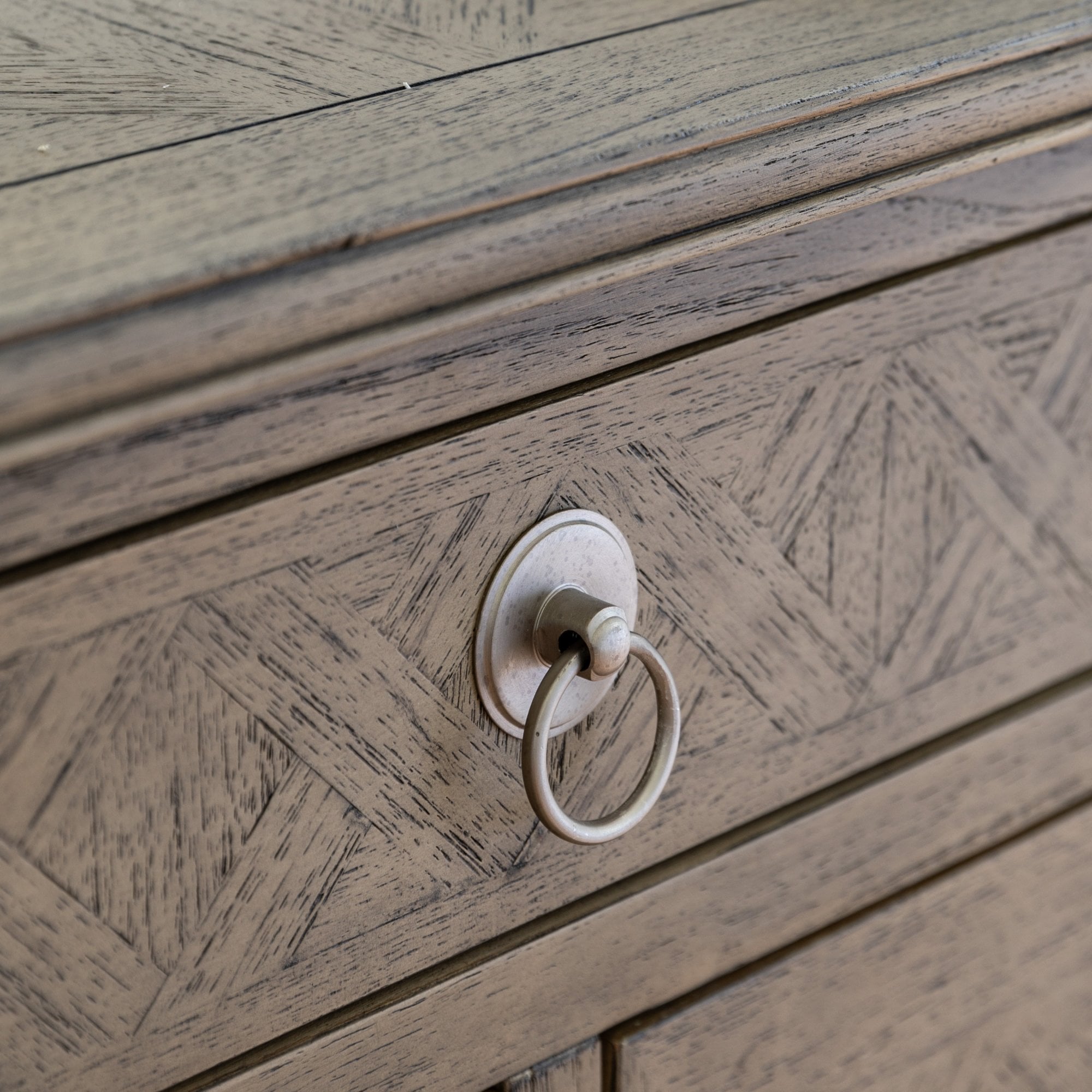 Close-up of a drawer with a decorative ring pull.