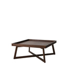 A wooden coffee table with a carved pattern, angled view.