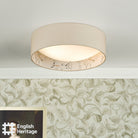 An English Heritage ceiling light with a bird and blossom pattern in a room with patterned wallpaper.