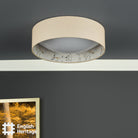 An English Heritage ceiling light with a bird and blossom pattern, off, in a room with a grey wall.