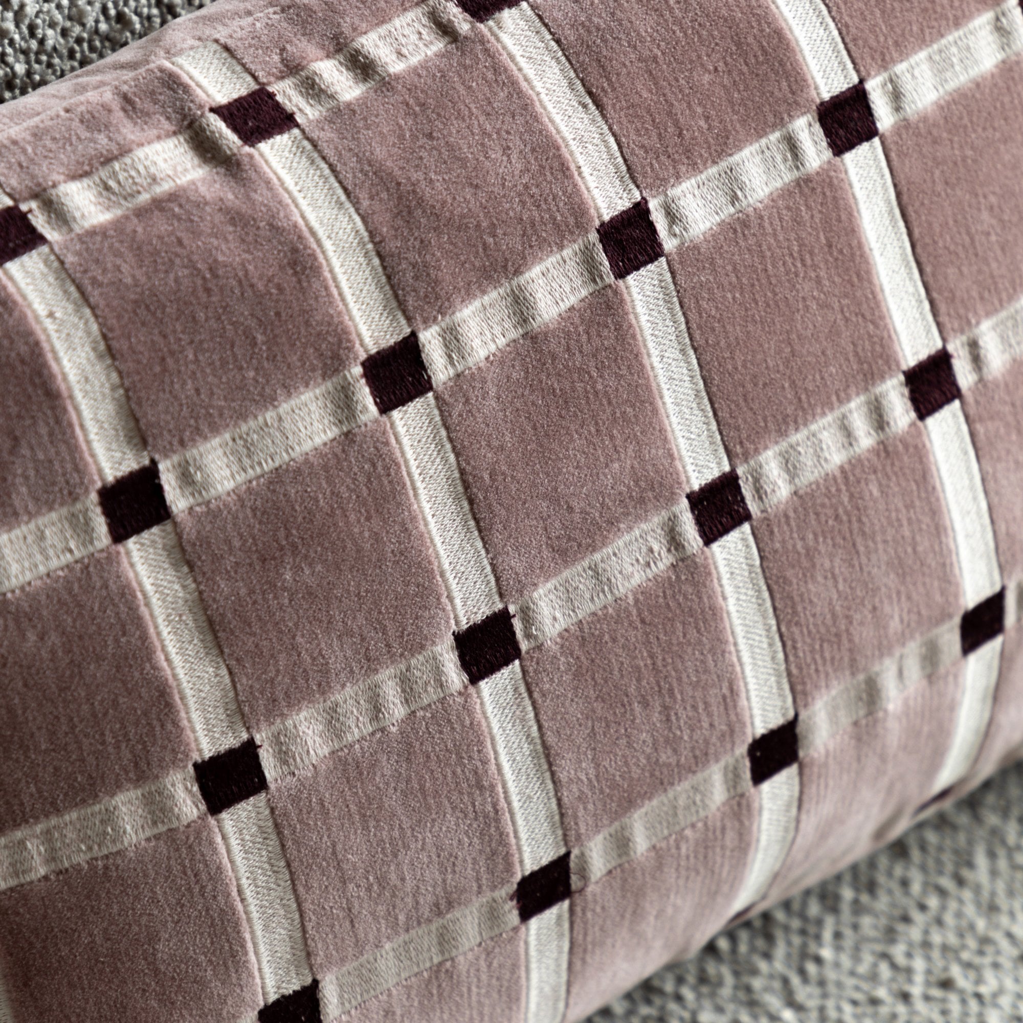 Close-up of the pink lumbar pillow showing the checkerboard pattern and texture.