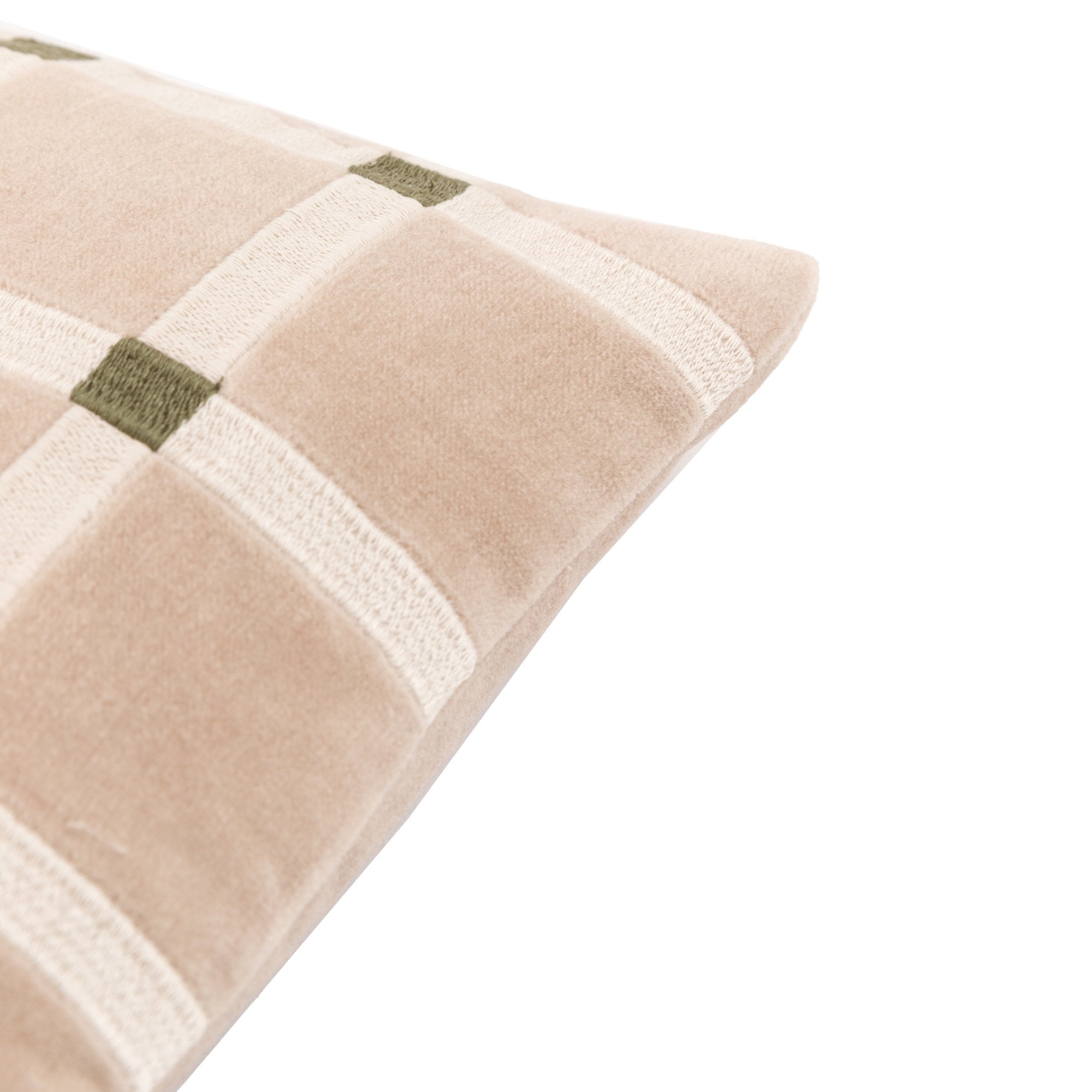 An extreme close-up of the beige and white plaid throw pillow's corner with green accents.