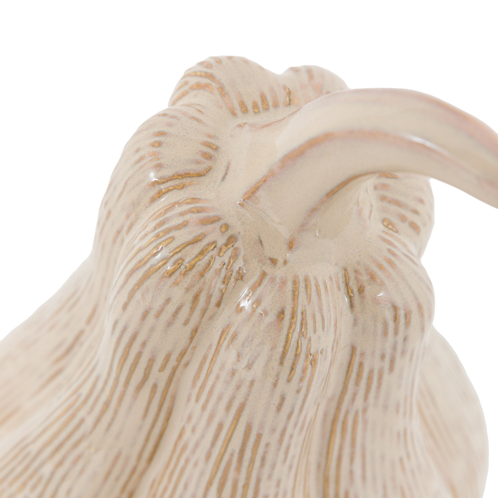 Close-up of the curved stem and textured top of a light beige ceramic gourd.