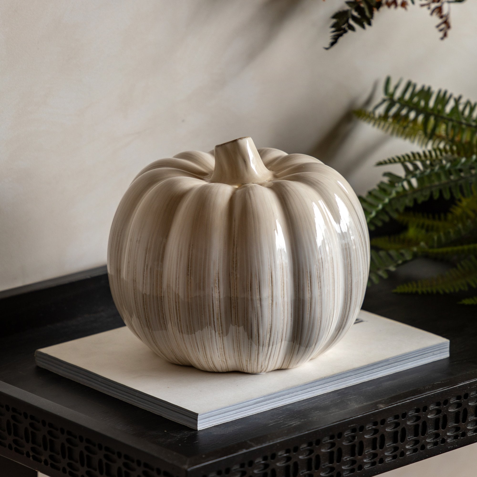 A decorative pumpkin with a shiny finish, perfect for festive seasonal decor.