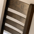 Close-up of the ladder-back design on an oak dining chair.
