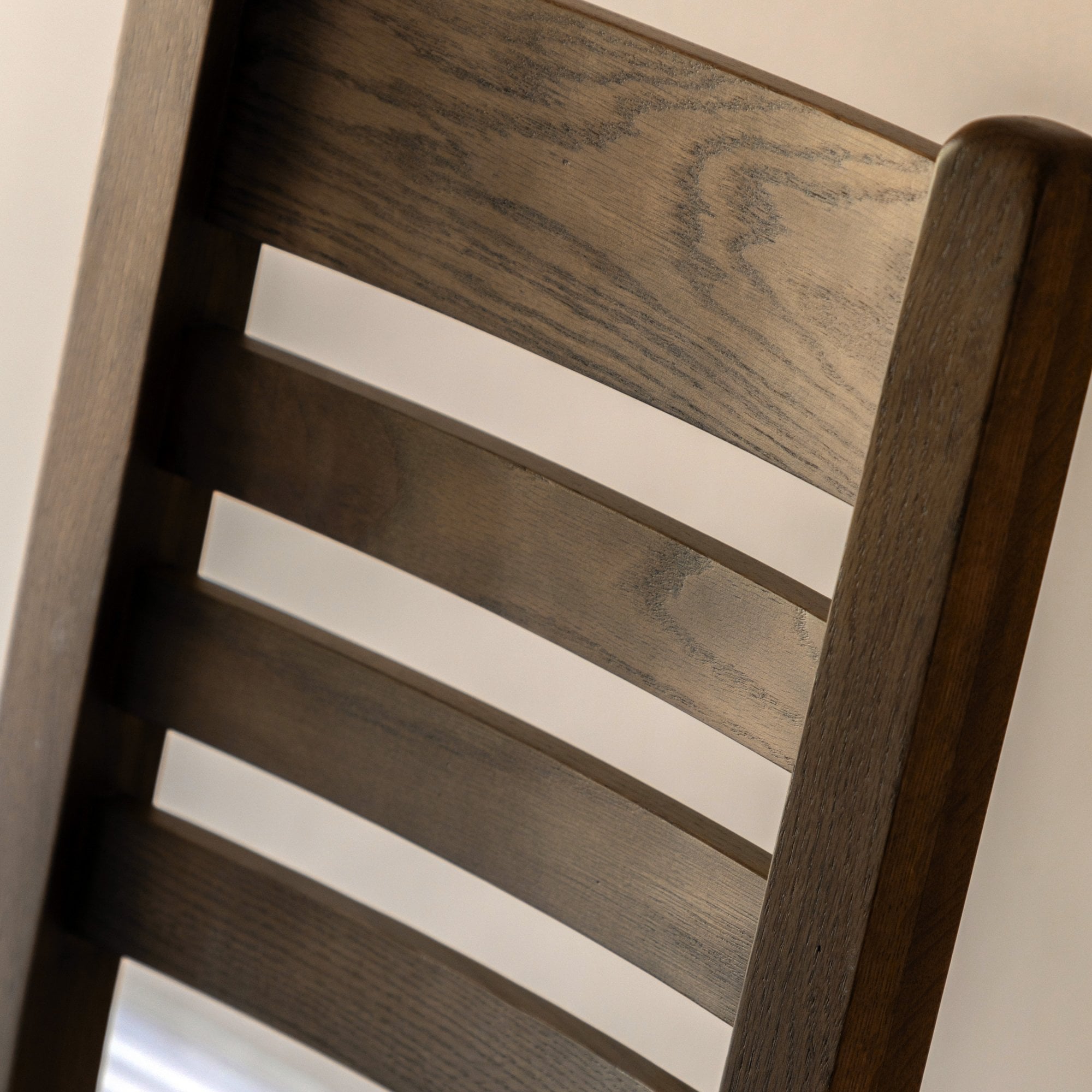 Close-up of the ladder-back design on an oak dining chair.