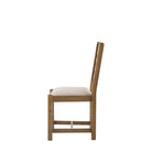 Side view of a single oak ladder-back dining chair with a cream seat.