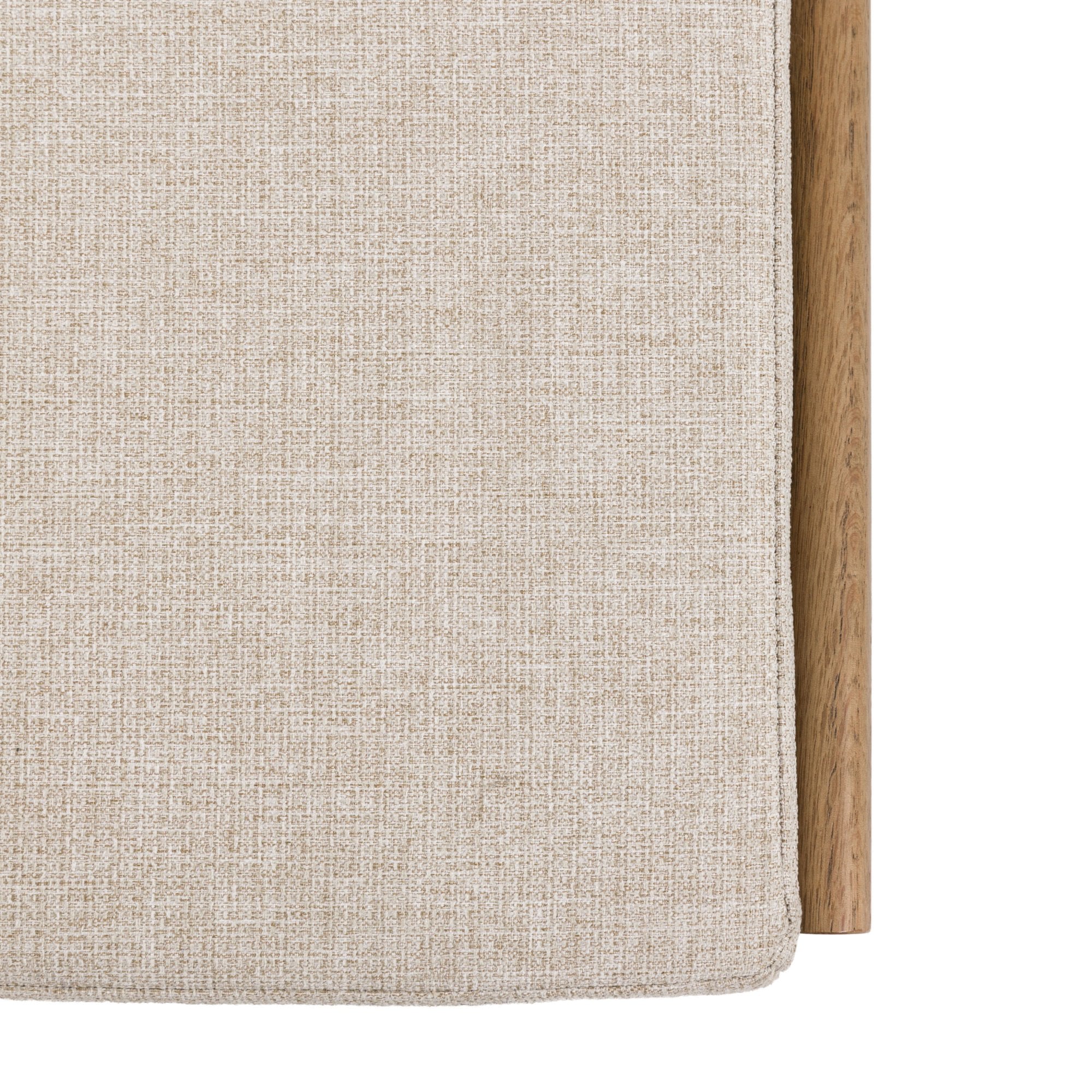 A close-up of the upholstered cushion on the wooden storage bench.