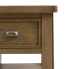 Close-up of a drawer on the rustic wooden kitchen island, focusing on the handle.