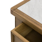 Close-up of the marble top and an open drawer on the rustic wooden kitchen island.