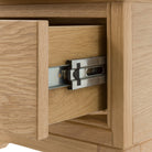 The detail of an open drawer of a bedside table.