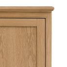 A close-up of the upper left corner of the wooden sideboard.