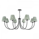 Elegant 8-arm chandelier with patterned green shades, ideal for a dining room.