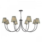 A black chandelier with eight arms and patterned lampshades.