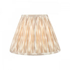 A pleated lamp shade in an off-white and pale brown vertical stripe pattern.