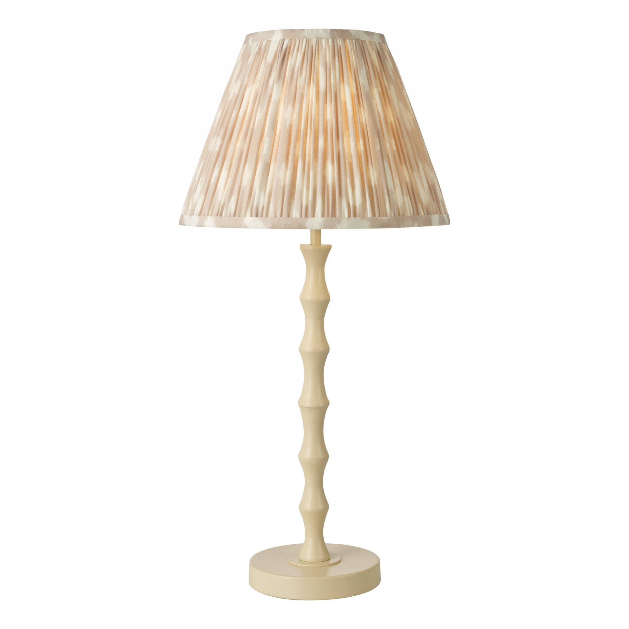 A tall lamp with a light cream bamboo-style base and a pleated shade in a pale stripe pattern.