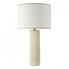A white fluted table lamp with a cream shade, against a white background.