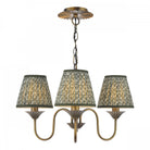 A vintage brass chandelier with three patterned green fabric shades.