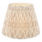 A white and beige pleated tapered drum lamp shade for table lamps or floor lamps.