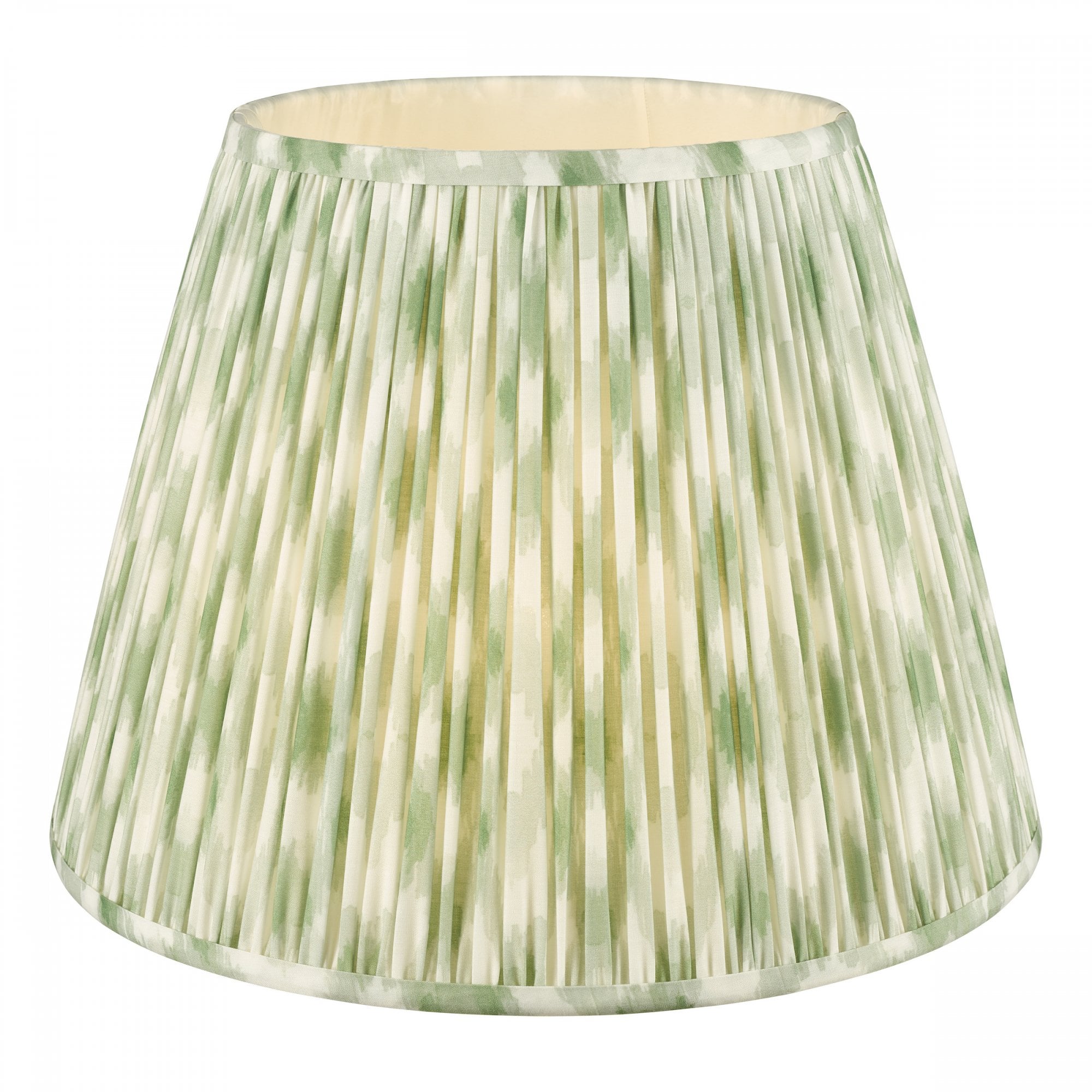Green and white pleated lampshade with light glowing.