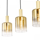 Close-up of three gold and clear glass pendant lights with exposed filament bulbs.