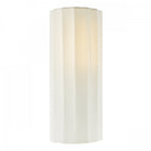A white fluted wall light casts a warm glow, showcasing its textured design.