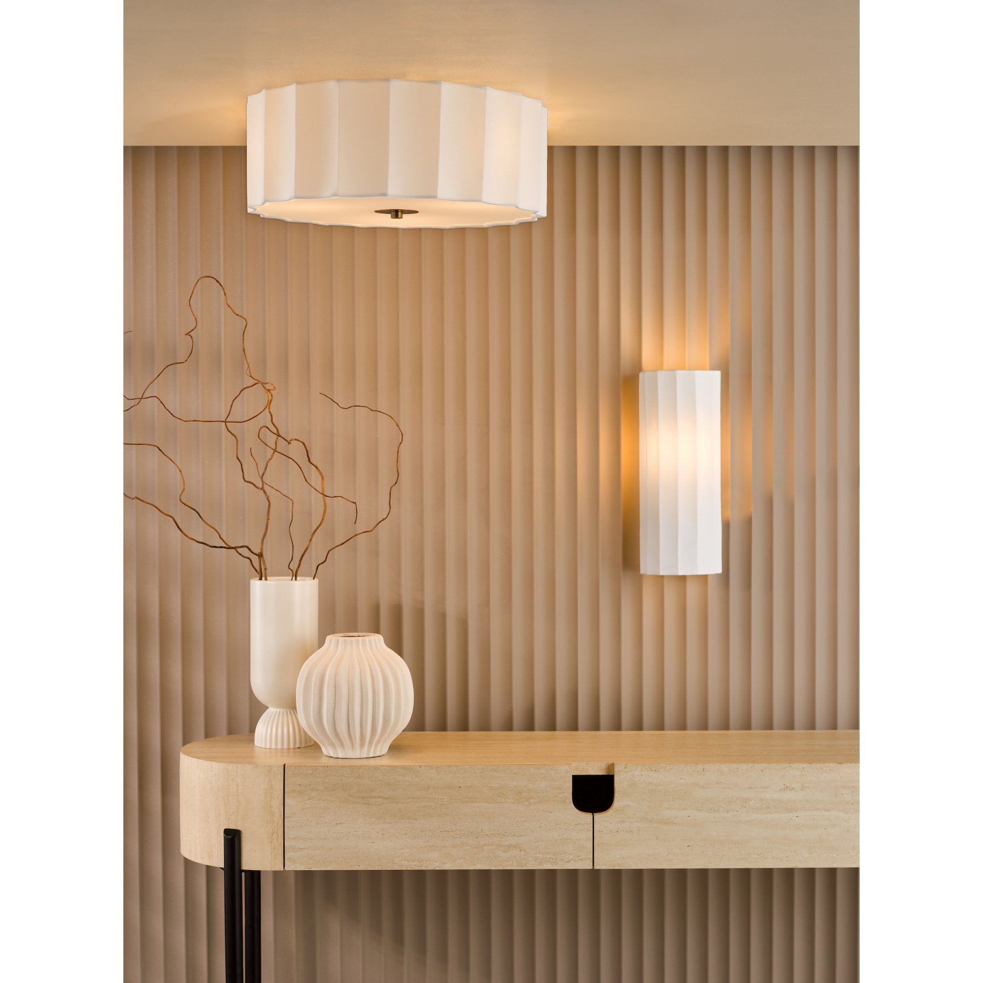 A white fluted wall light and matching ceiling light illuminate a modern entry with decor.