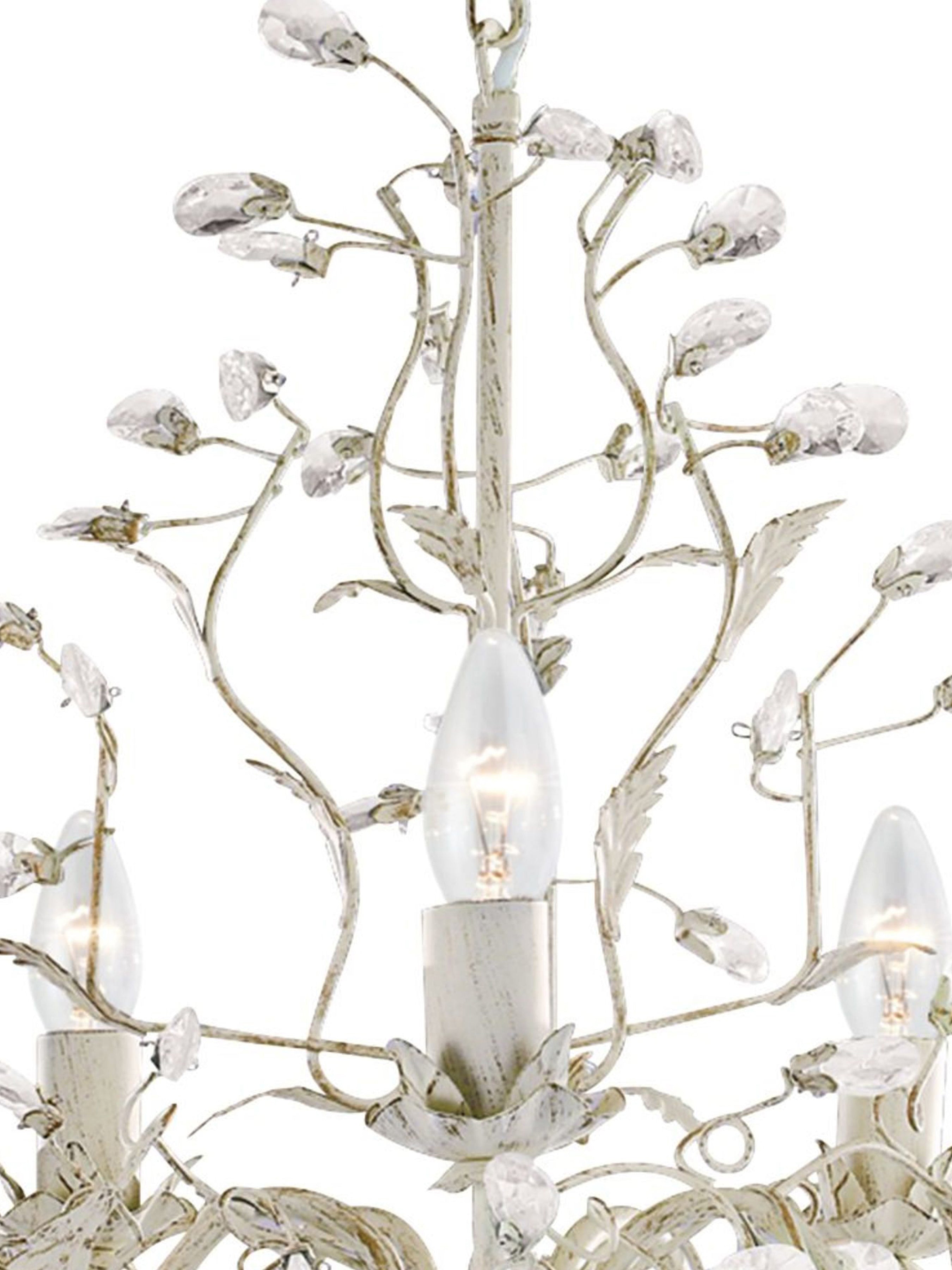 Close-up of the white and crystal chandelier, highlighting its intricate details.