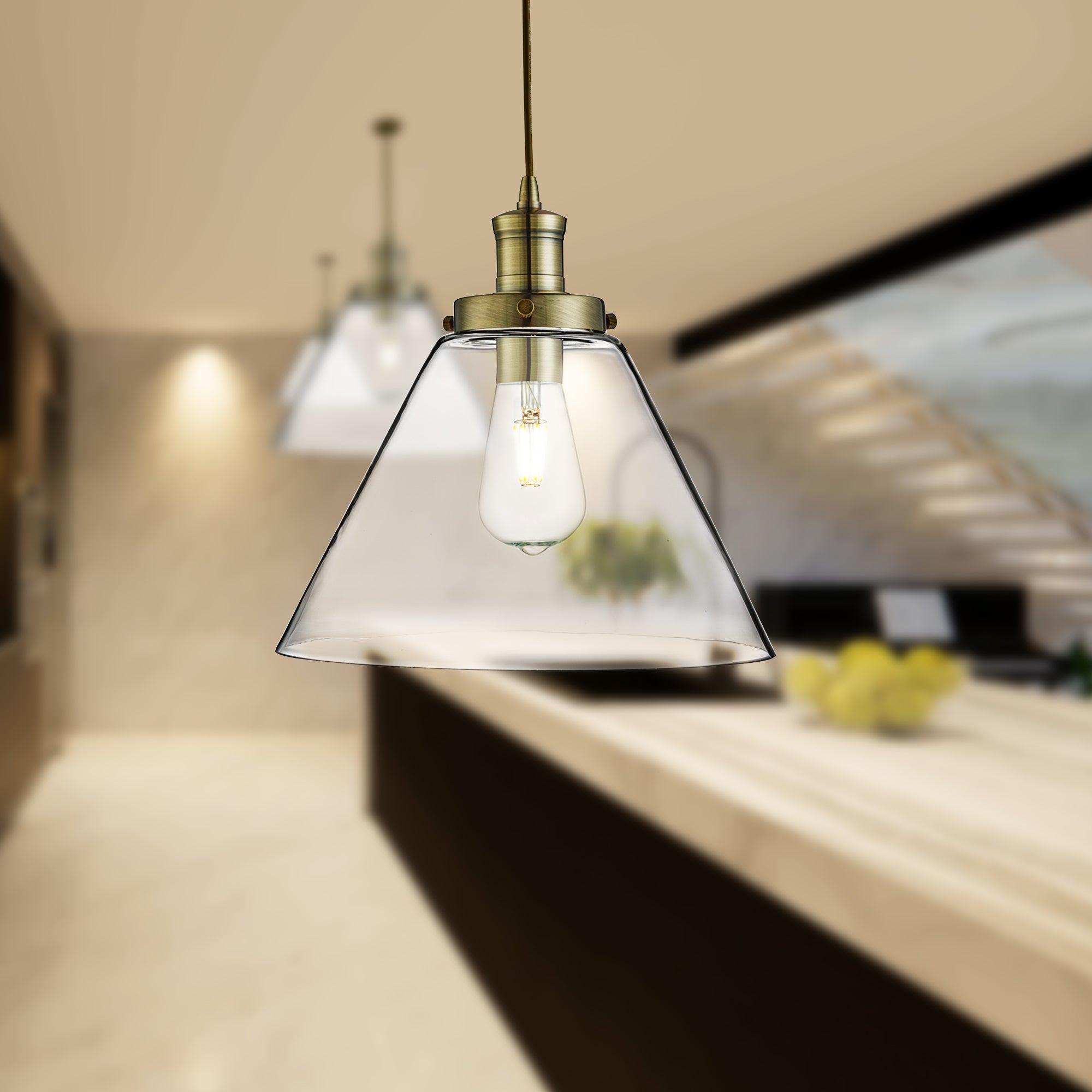 Two brass and glass cone pendant lights illuminate a modern kitchen island.
