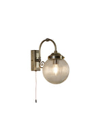 Vintage brass wall light with a ribbed glass globe and pull cord switch.