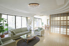 A modern living room with a crystal chandelier providing ambient light.