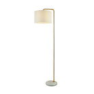 An elegant floor lamp with a gold stand, round base, and cream drum shade, illuminated against a white background.