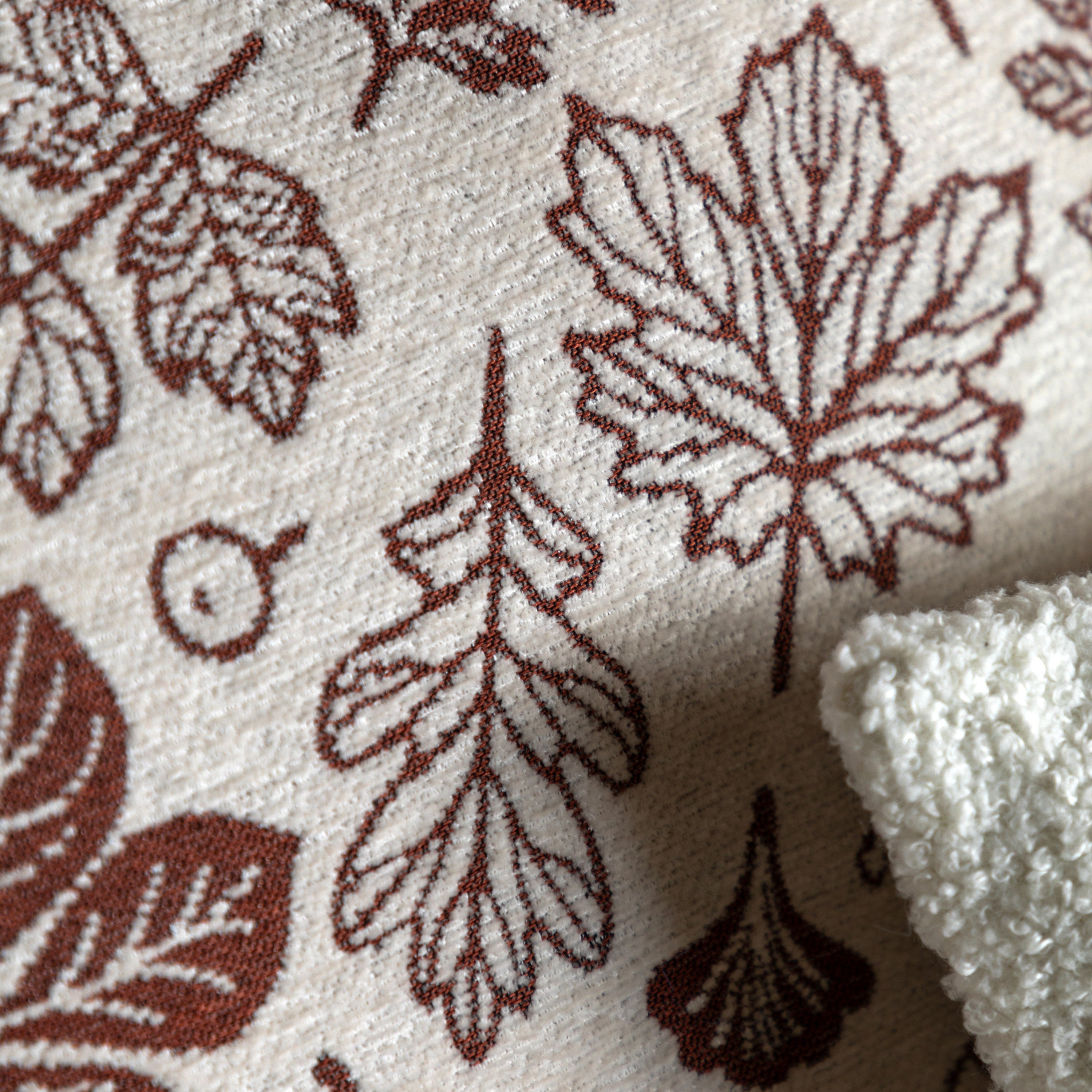 A close-up of the red autumn leaf pattern on a cream fabric.