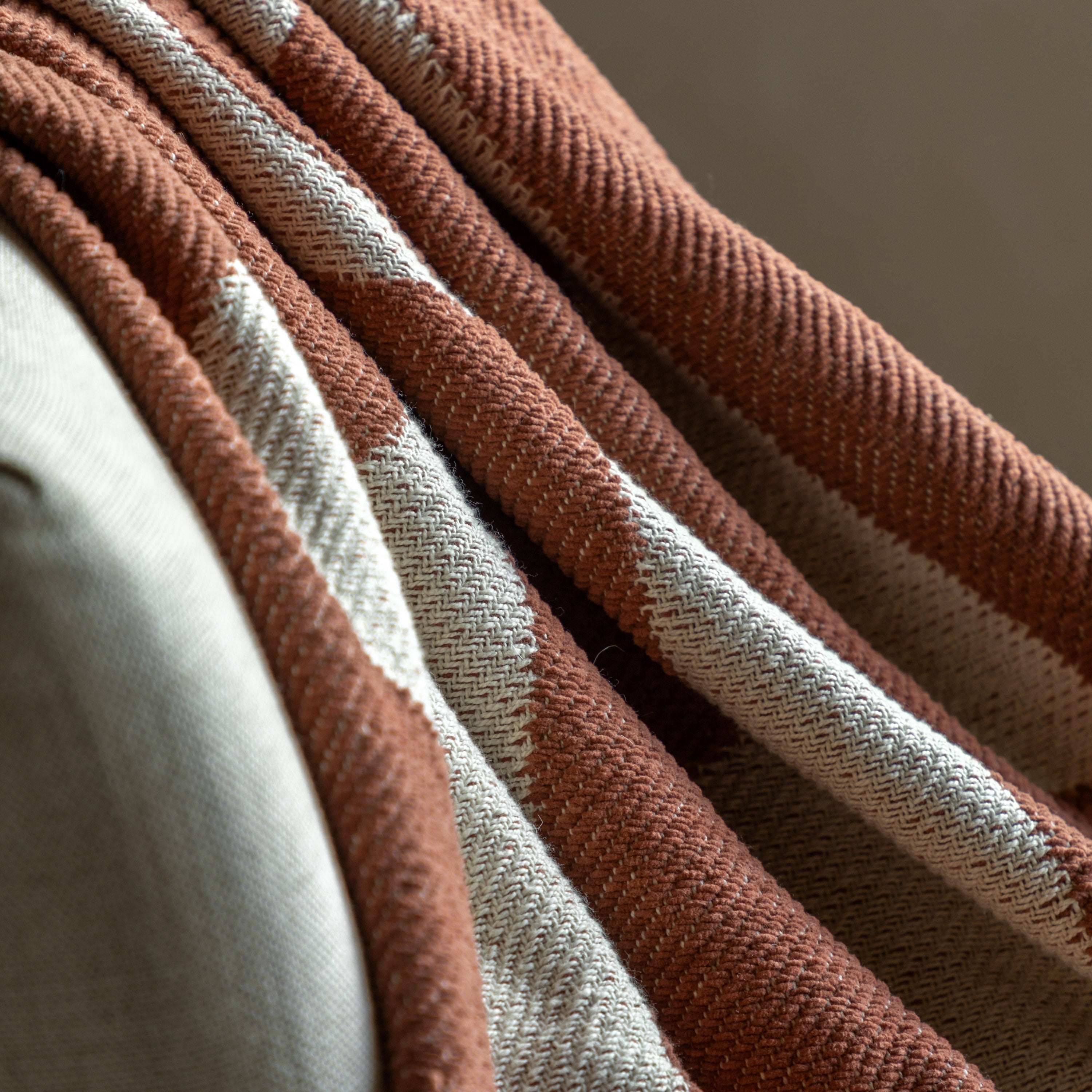 Detailed view of the burnt orange and off-white abstract pattern on a boho throw blanket.