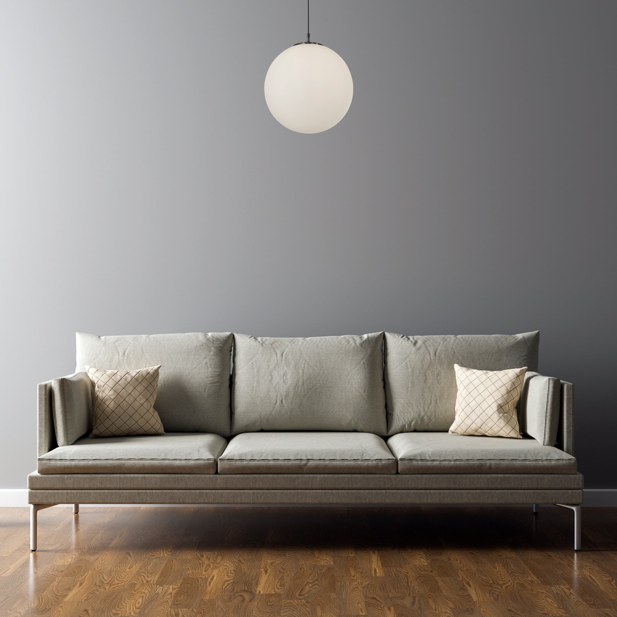 A white spherical pendant light hangs above a modern grey sofa in a minimalist room setting.