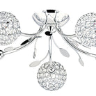 Close-up of a chrome ceiling light with crystal sphere shades and decorative leaf accents.