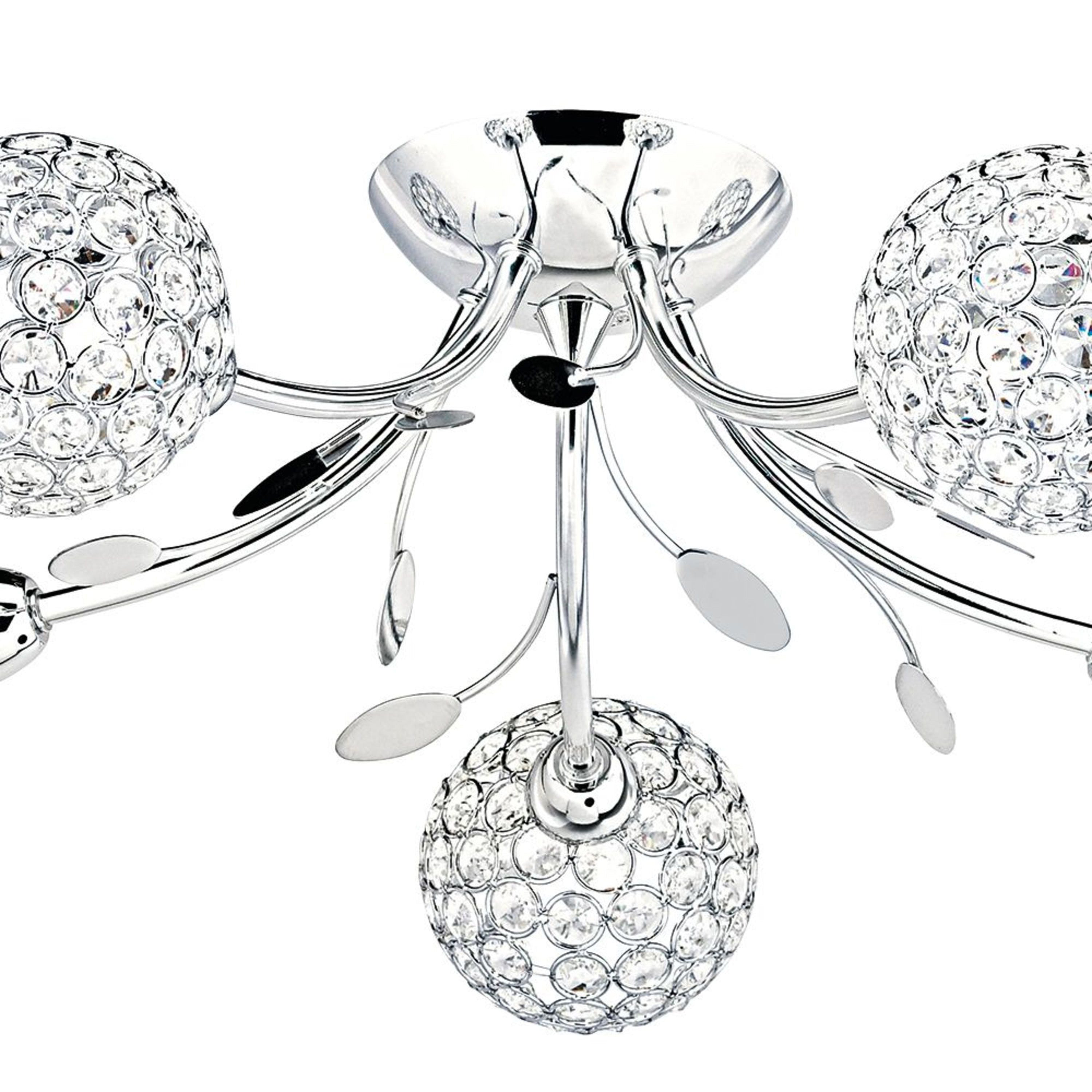 Close-up of a chrome ceiling light with crystal sphere shades and decorative leaf accents.