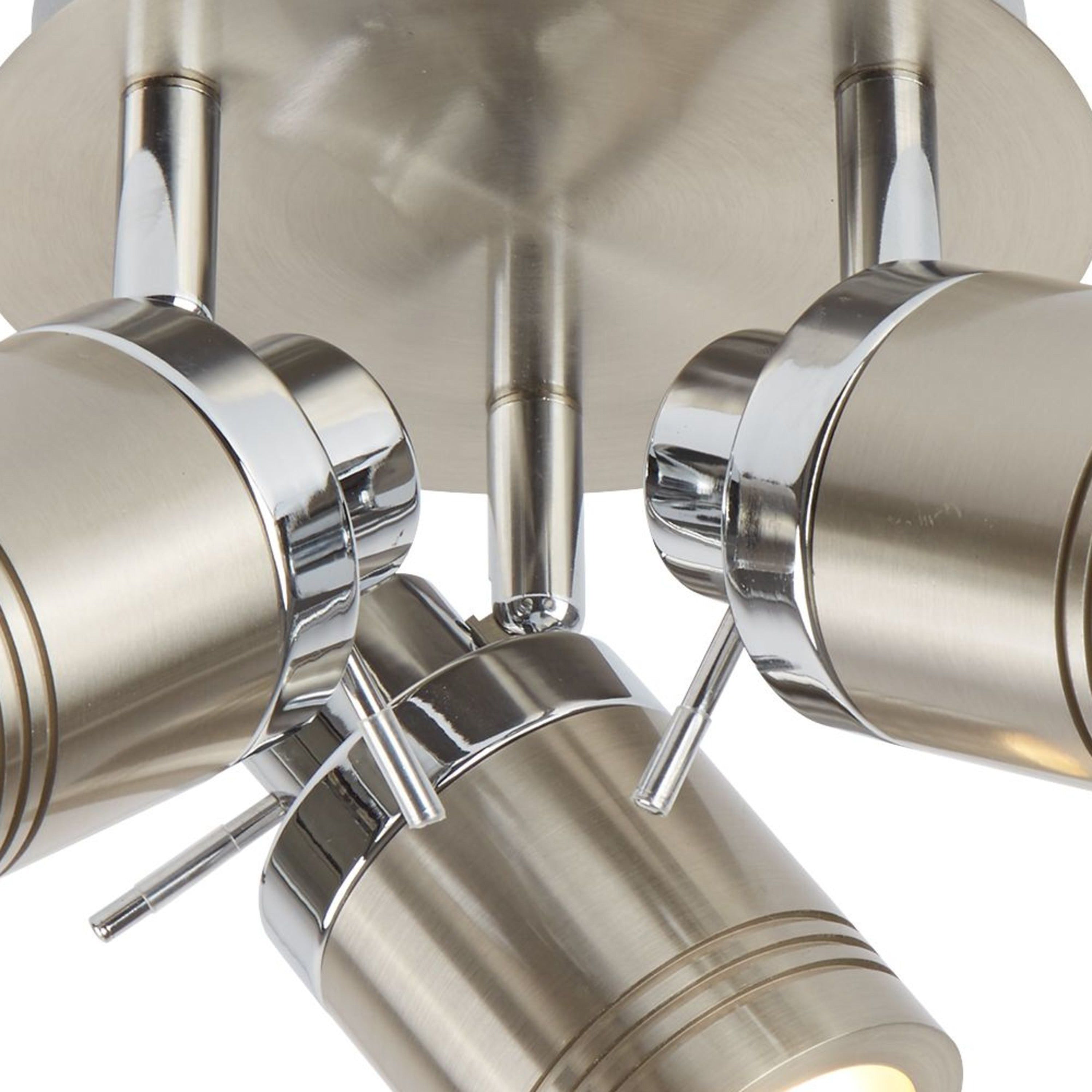 A close-up of four unlit ceiling spotlights in a brushed steel finish.