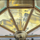 Close-up of the faceted glass and bronze frame of the octagonal ceiling light.