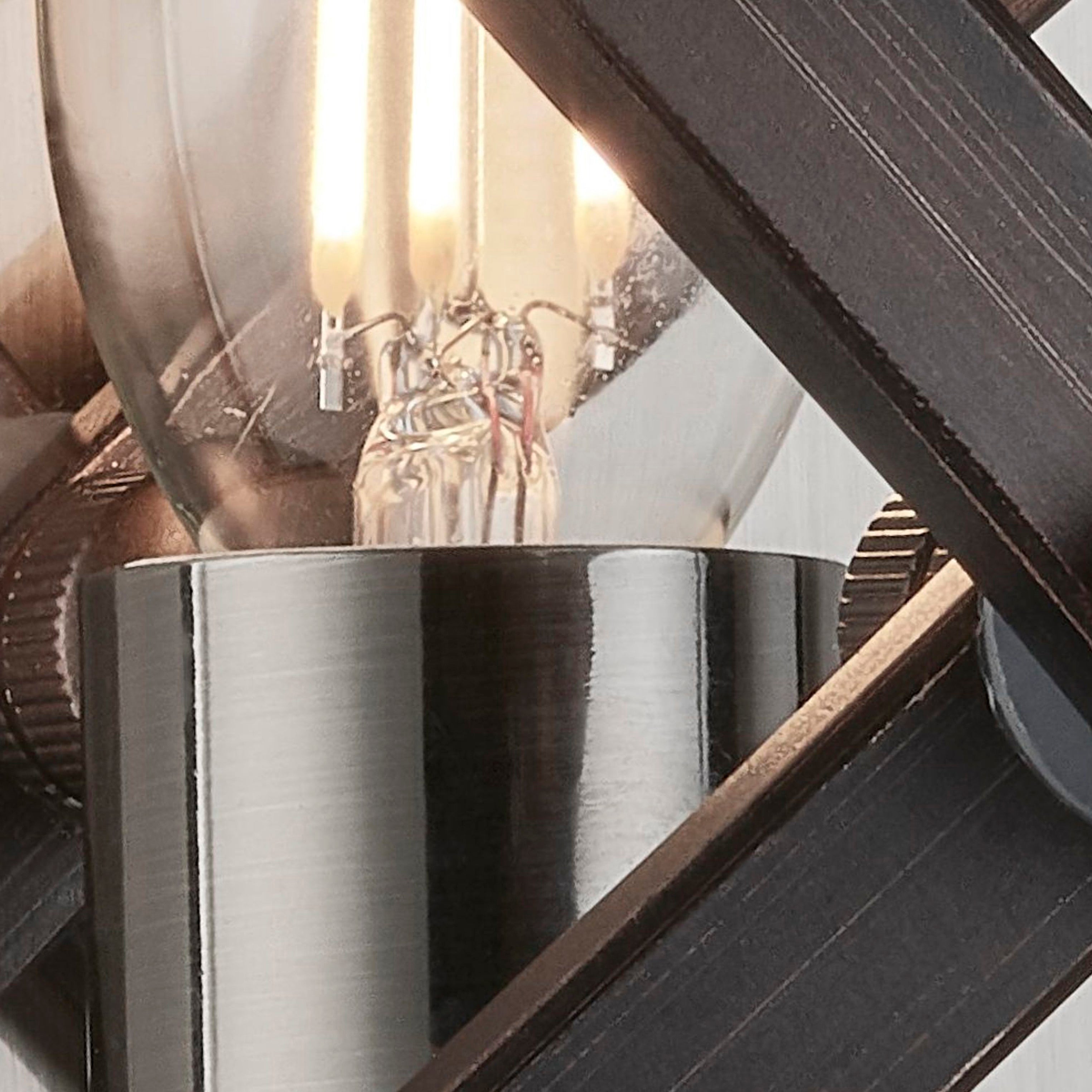 A detailed view of the light bulb and metal fixture of the wall sconce.