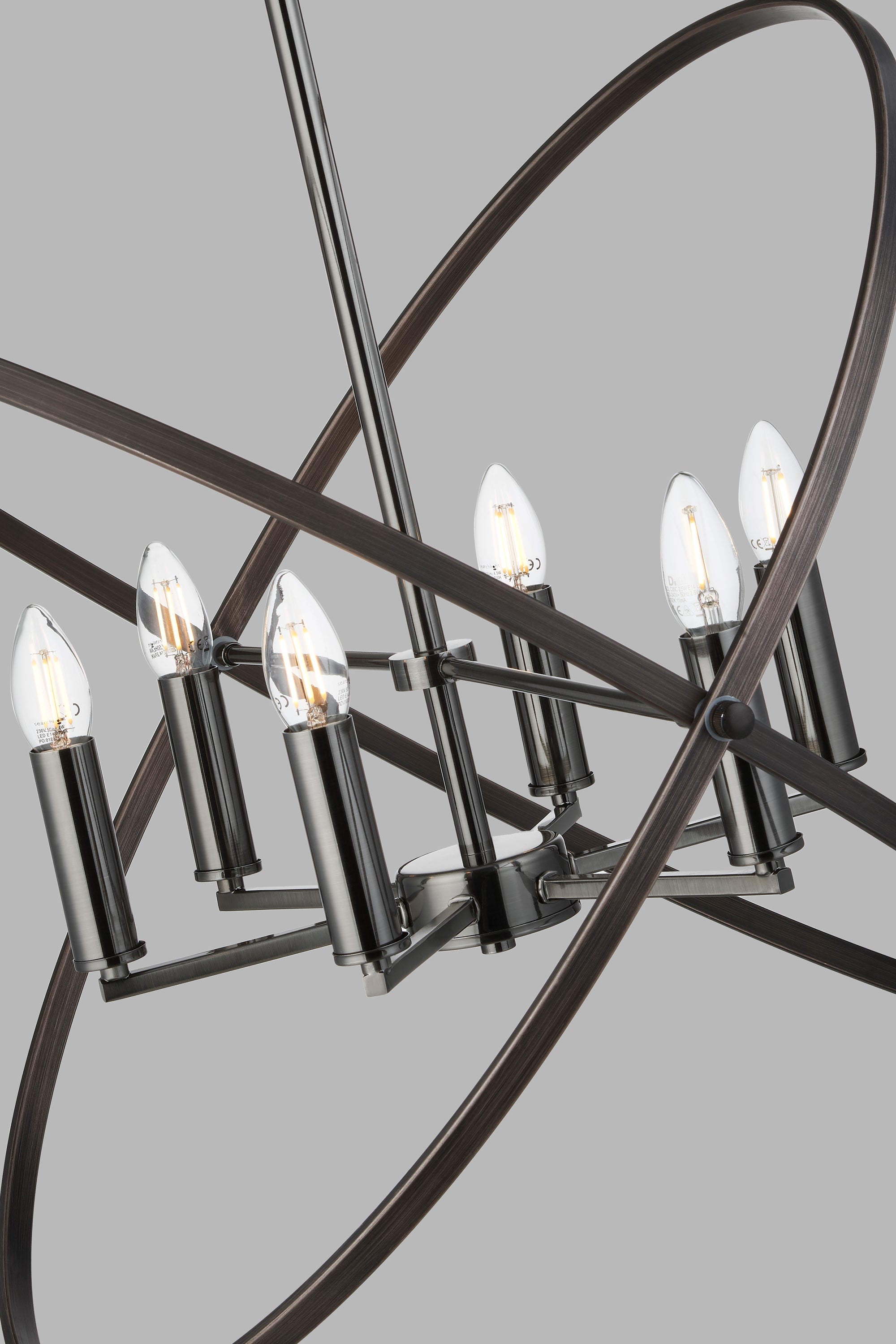 Close-up of a modern chandelier's six exposed bulbs and dark metal rings.