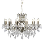 A 12-light crystal chandelier with a brass finish on a white background.