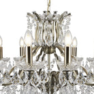 A close-up of a 12-light crystal chandelier with a brass finish.